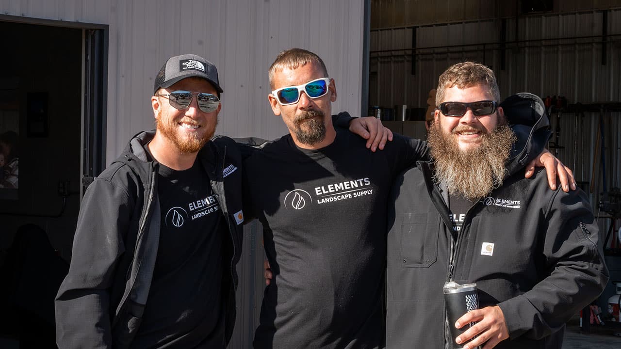 Three Elements crew members with arms around each other outside the shop