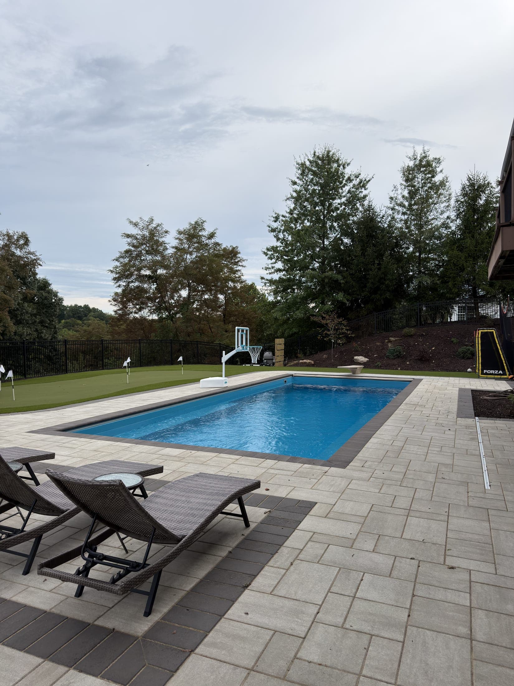 The finished pool, paver deck, and putting green