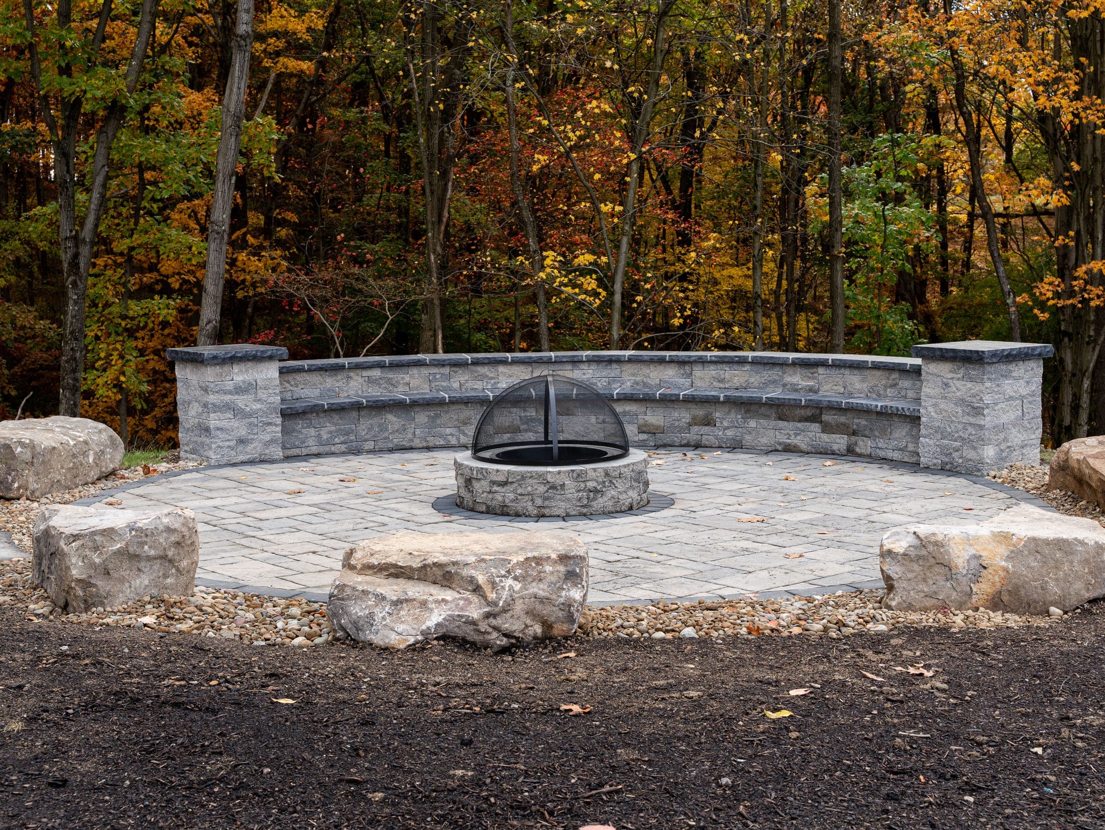 Fire pit with stone seating wall on a paver patio
