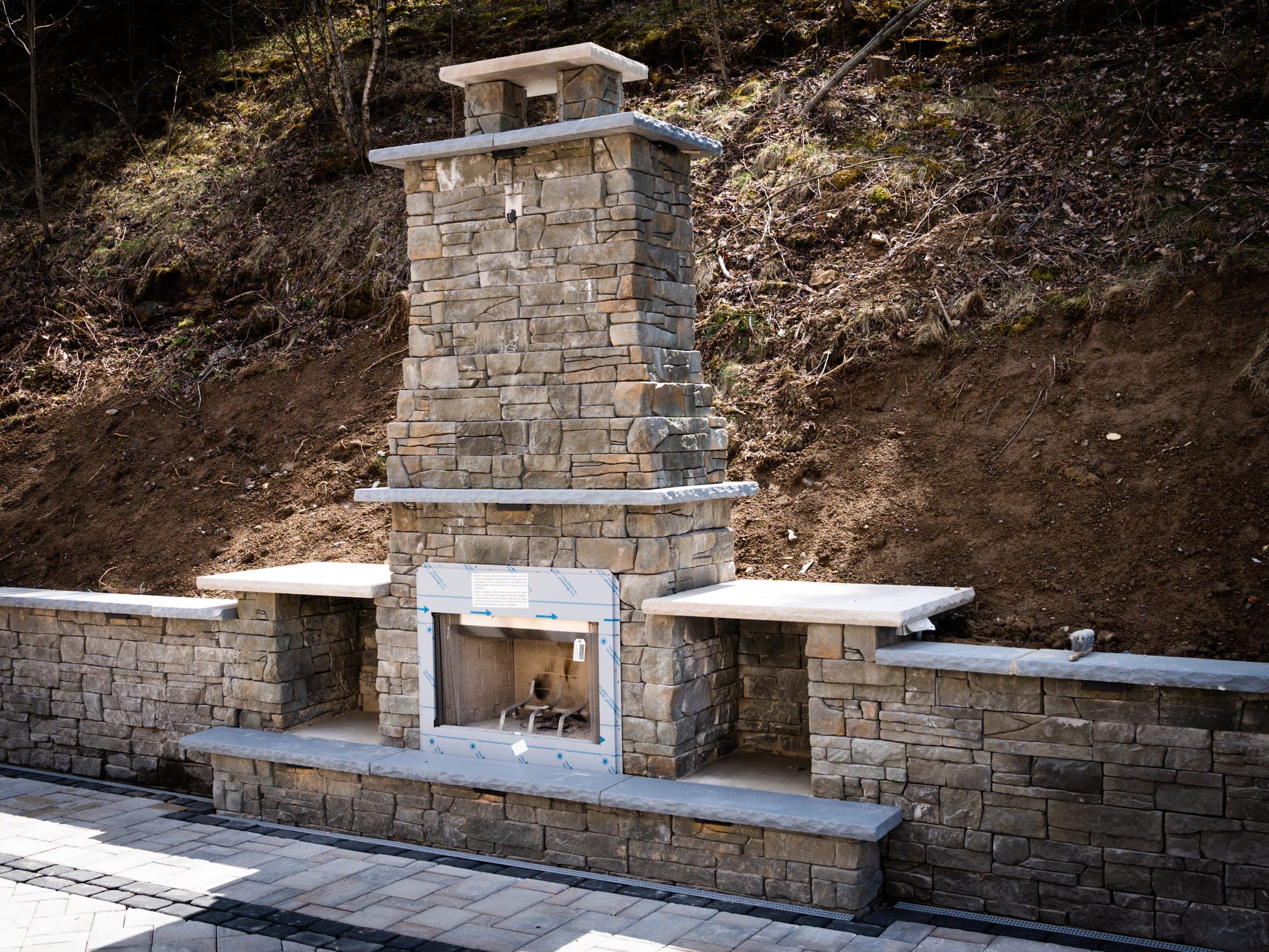stone fireplace seating area - Elements Landscape Management