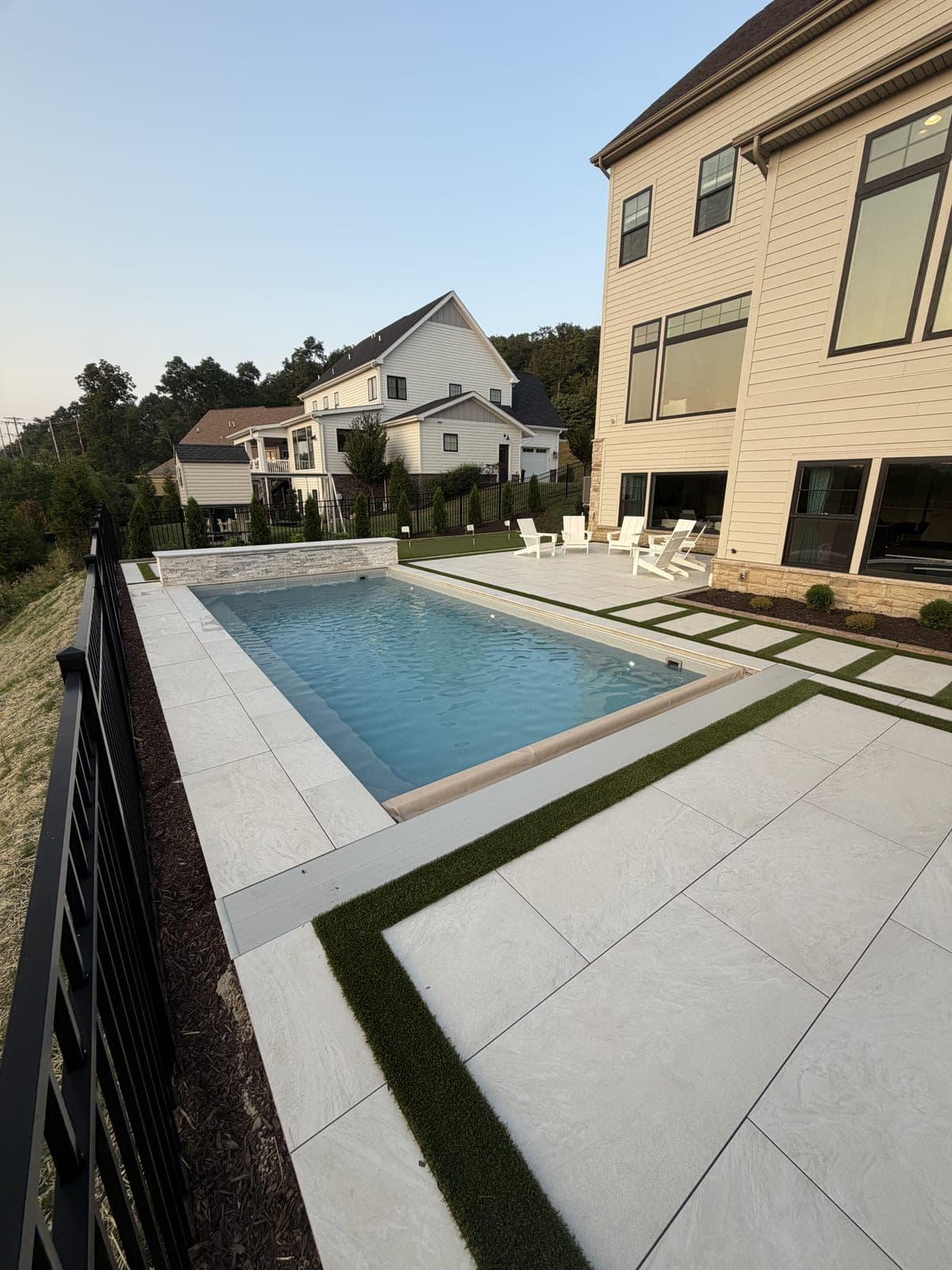 Inground pool with porcelain paver deck and artificial turf inlay