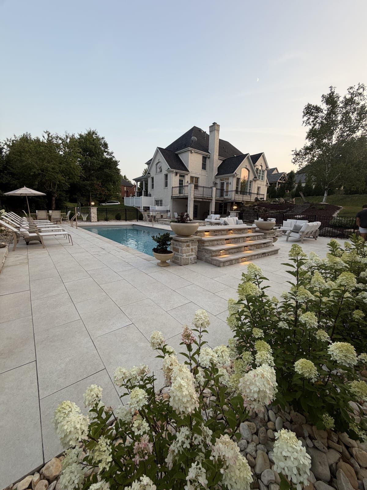 Illuminated pool steps with hydrangea landscaping