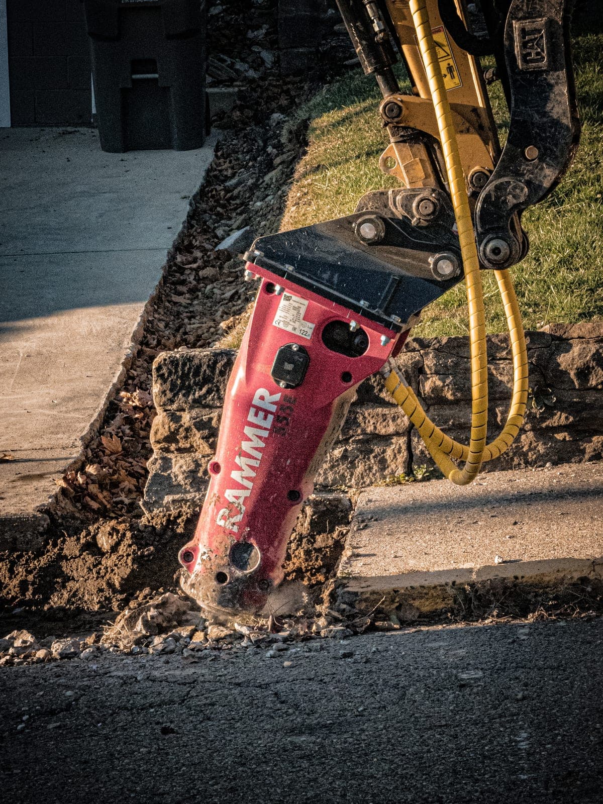 Hydraulic breaker attachment working through rock and concrete on a job site