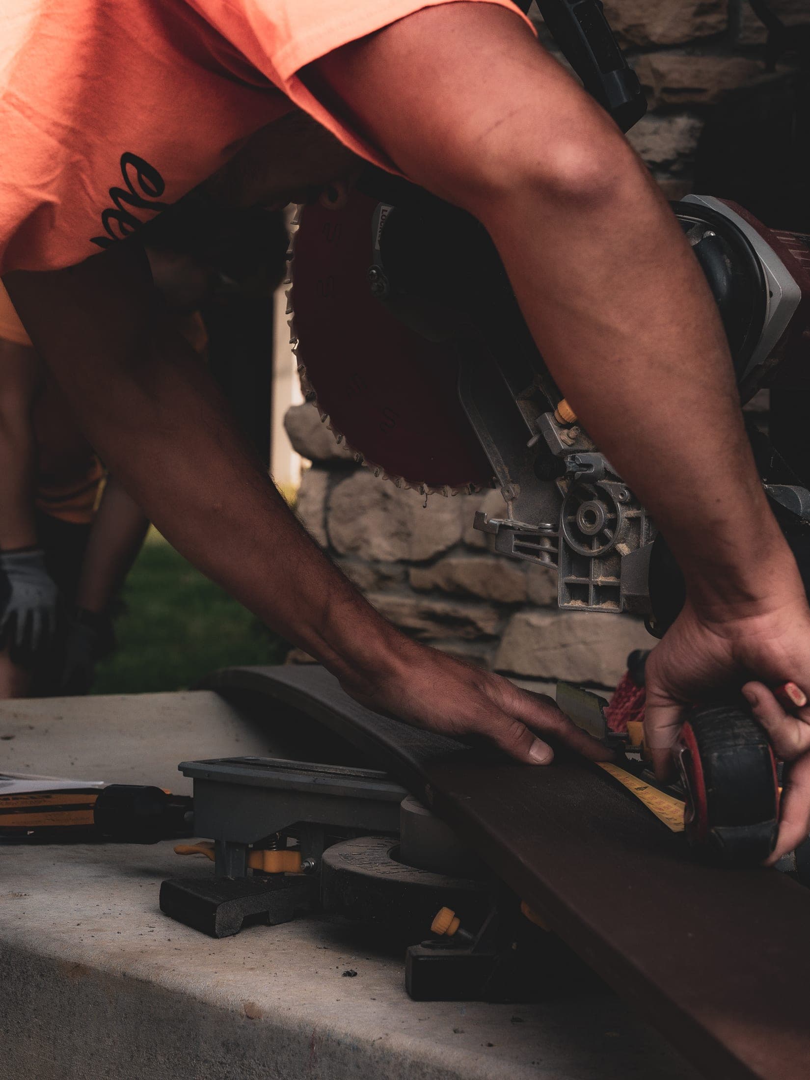 miter saw stone cutting closeup - Elements Landscape Management