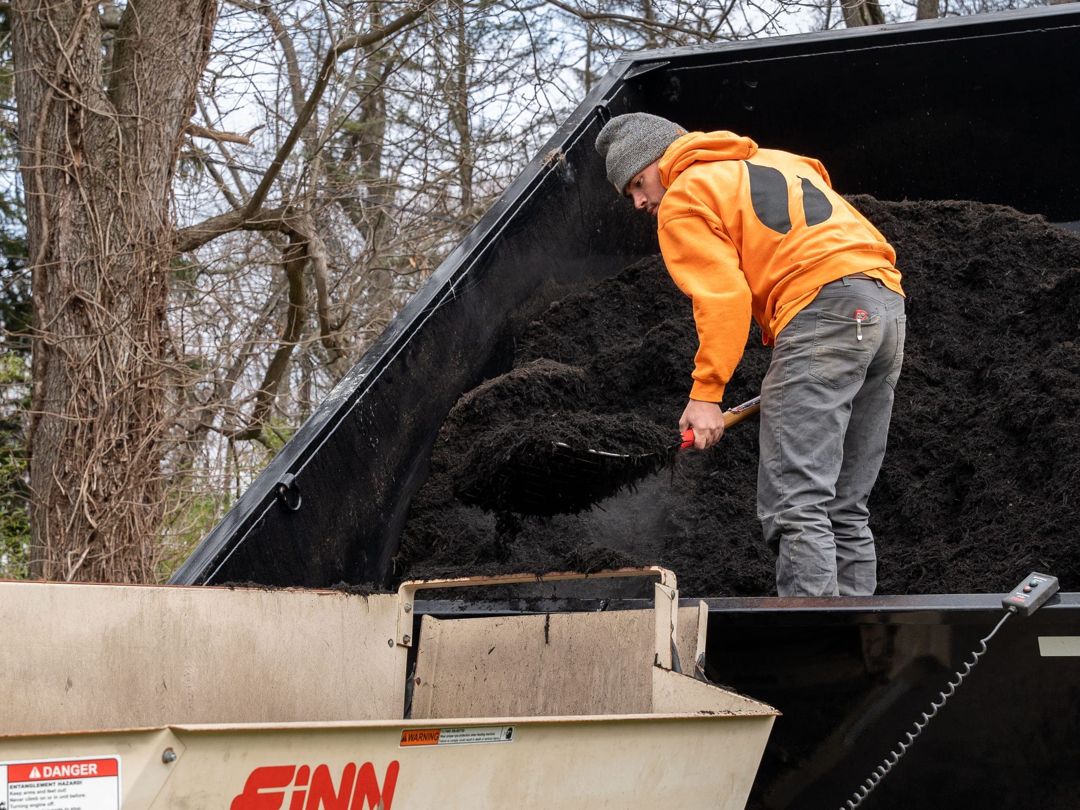 Mulch blower hose running from a truck bed during application
