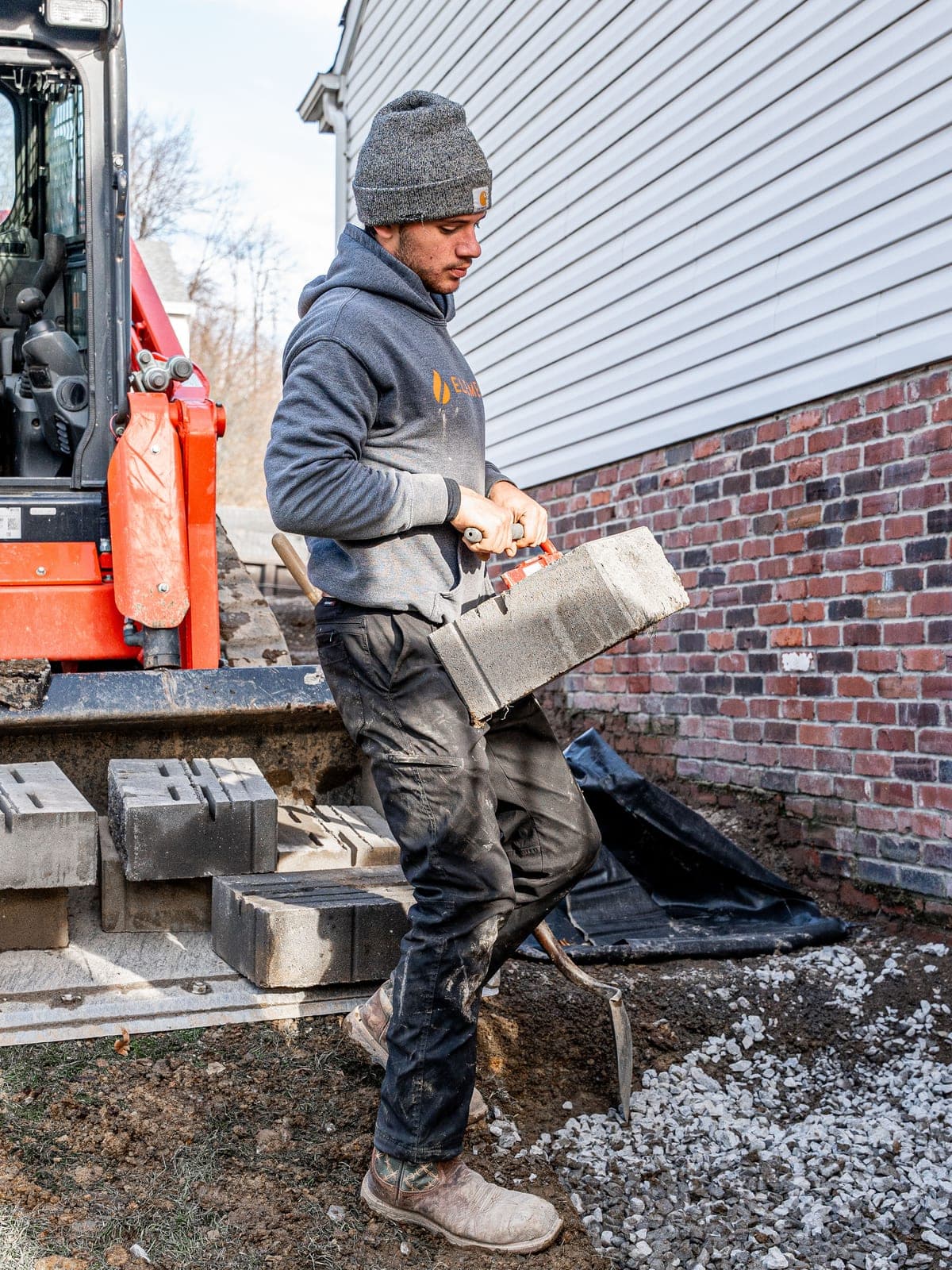 Skid steer setting retaining wall block during installation