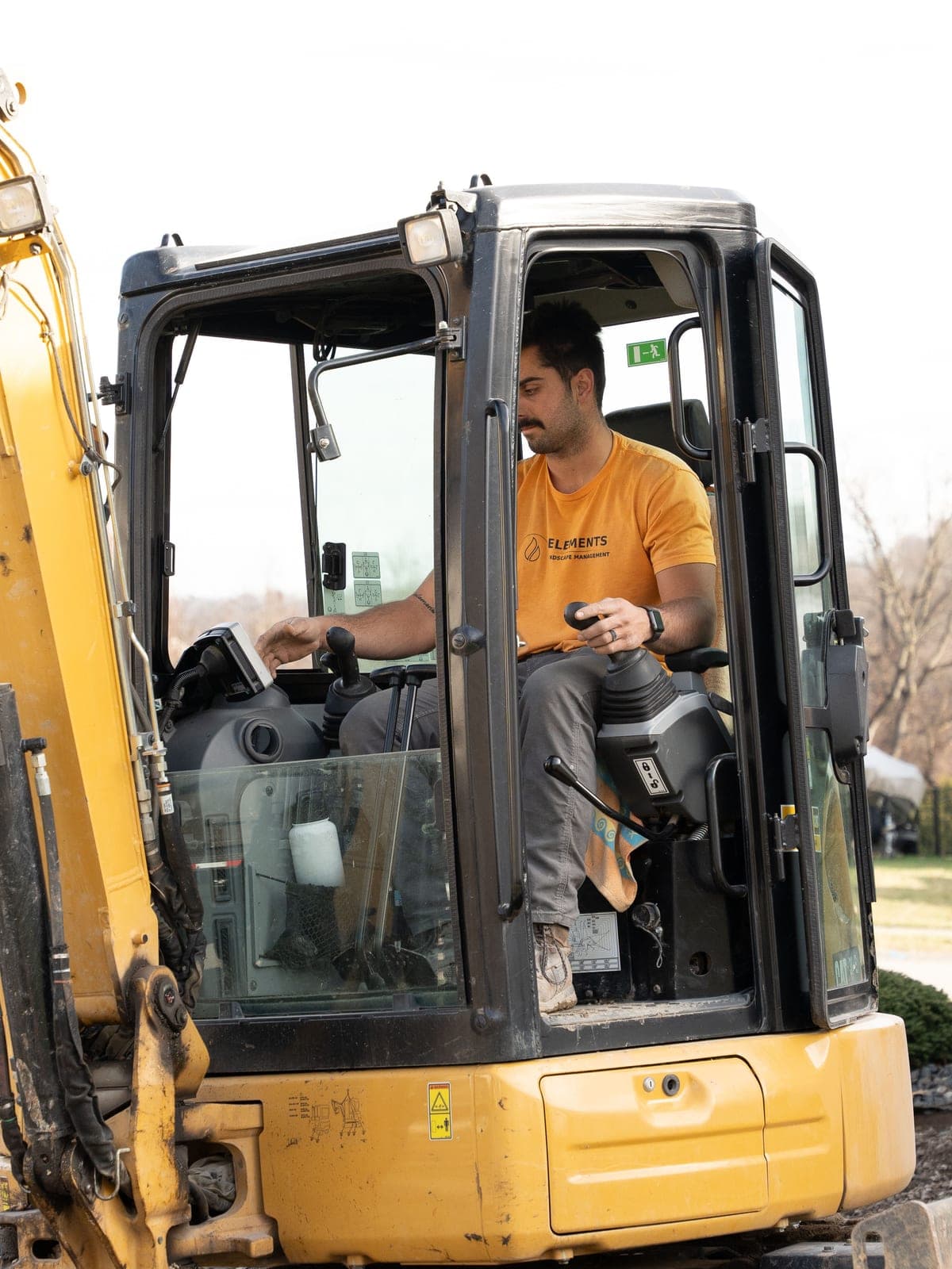 Elements crew member running one of the company's own excavators on site