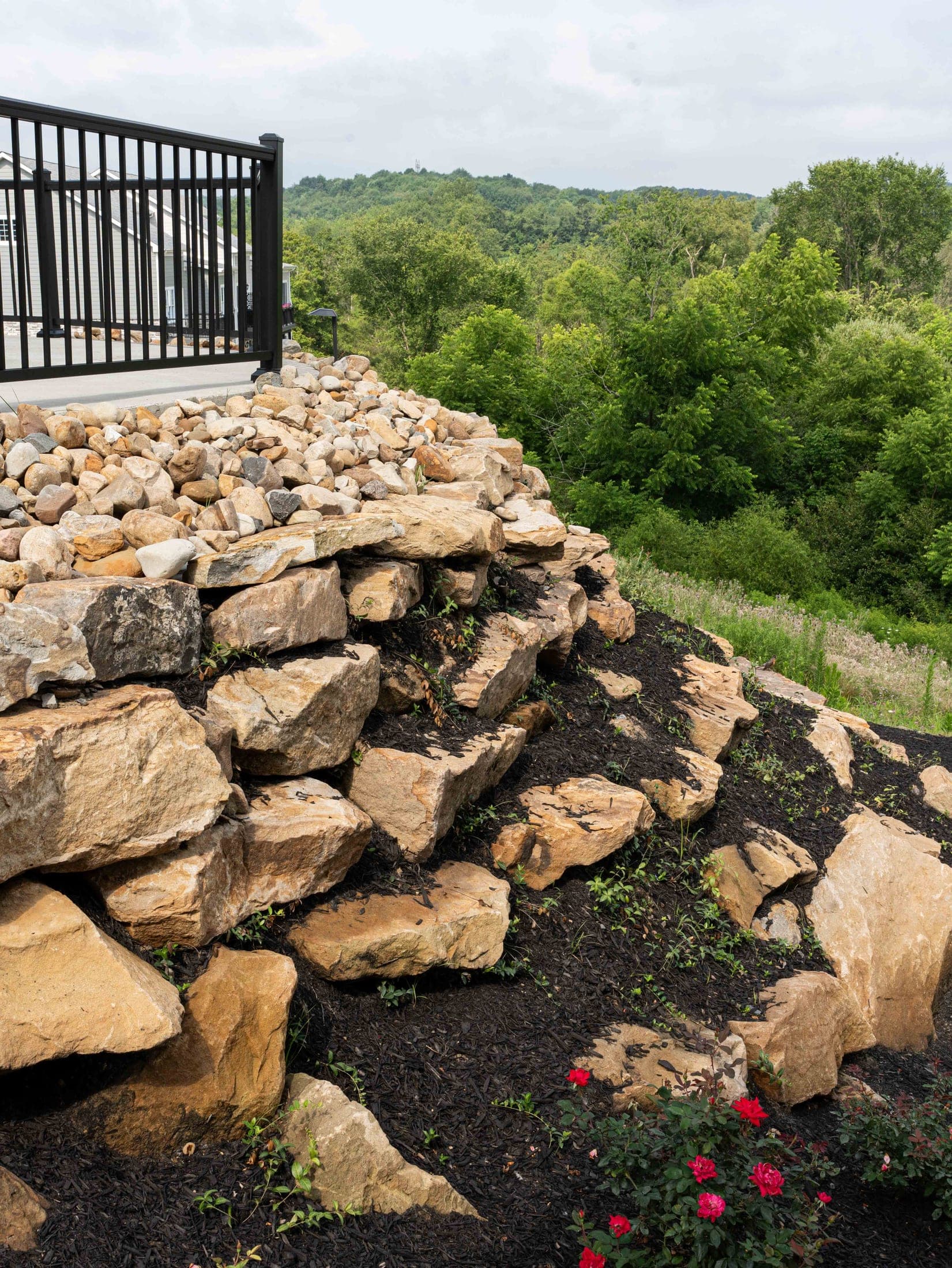 boulder retaining wall roses - Elements Landscape Management