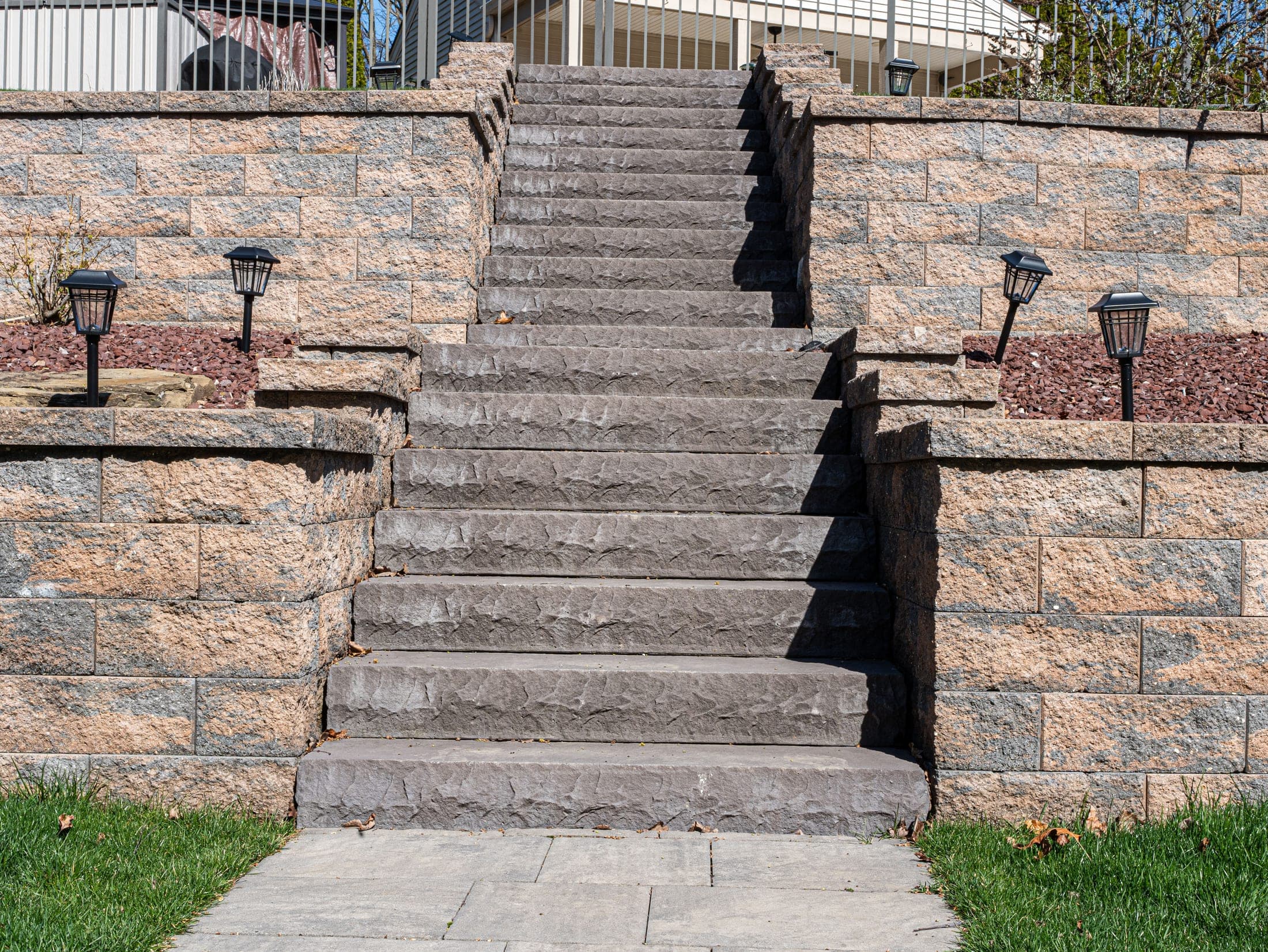 Grand stone staircase lit with lantern-style landscape lighting