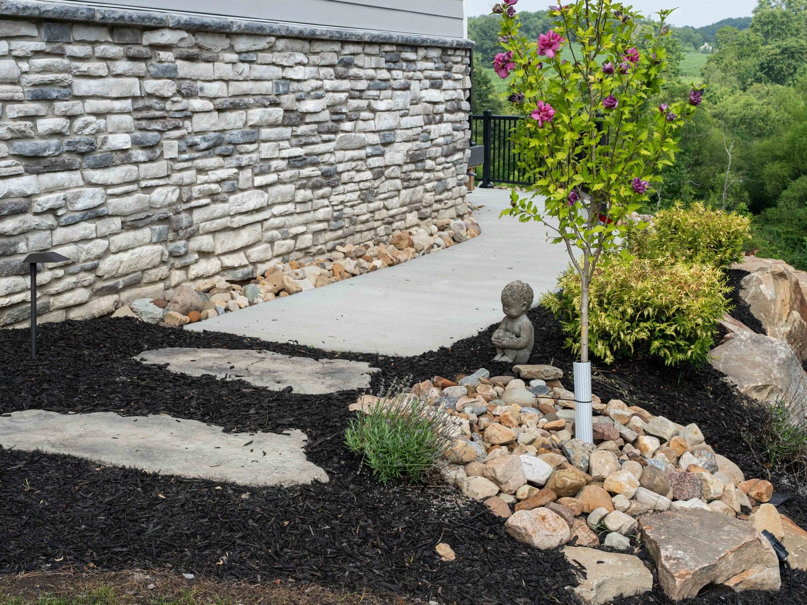 Flowering tree planted in a river rock landscape bed