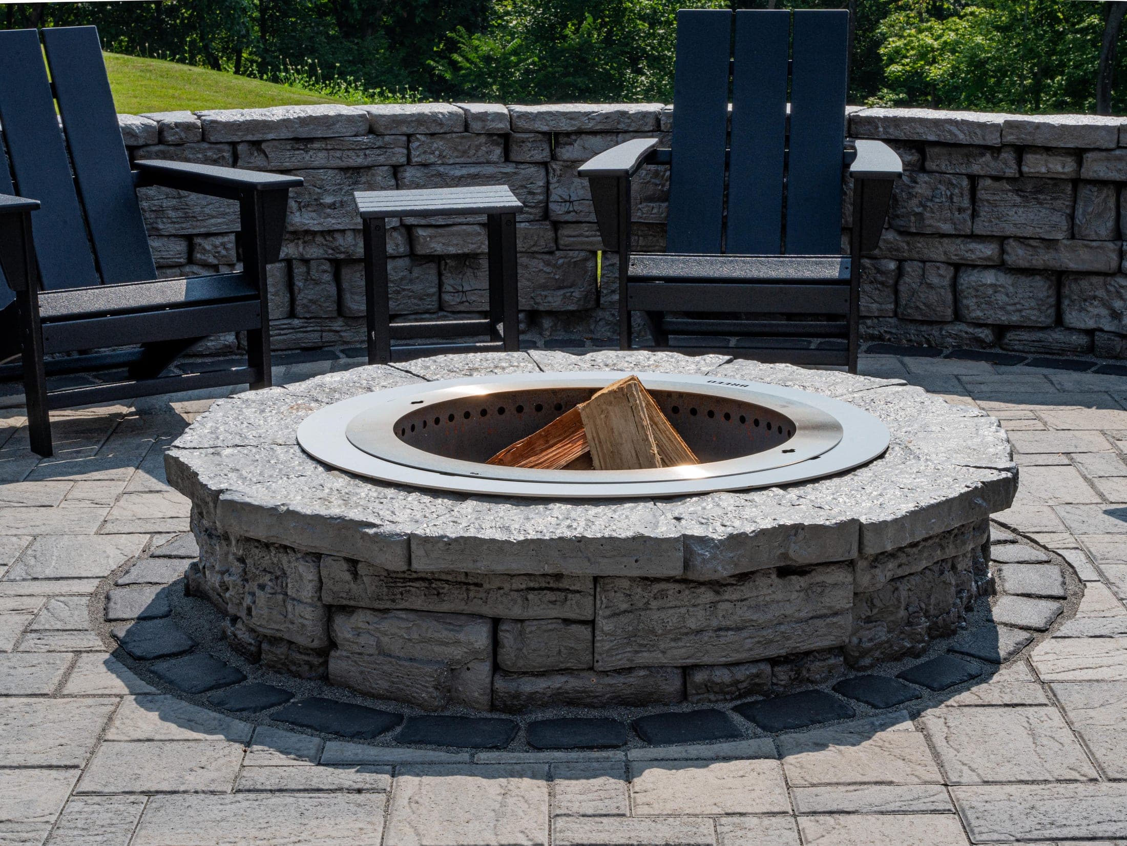 Fire pit patio with Adirondack chairs and a hillside view