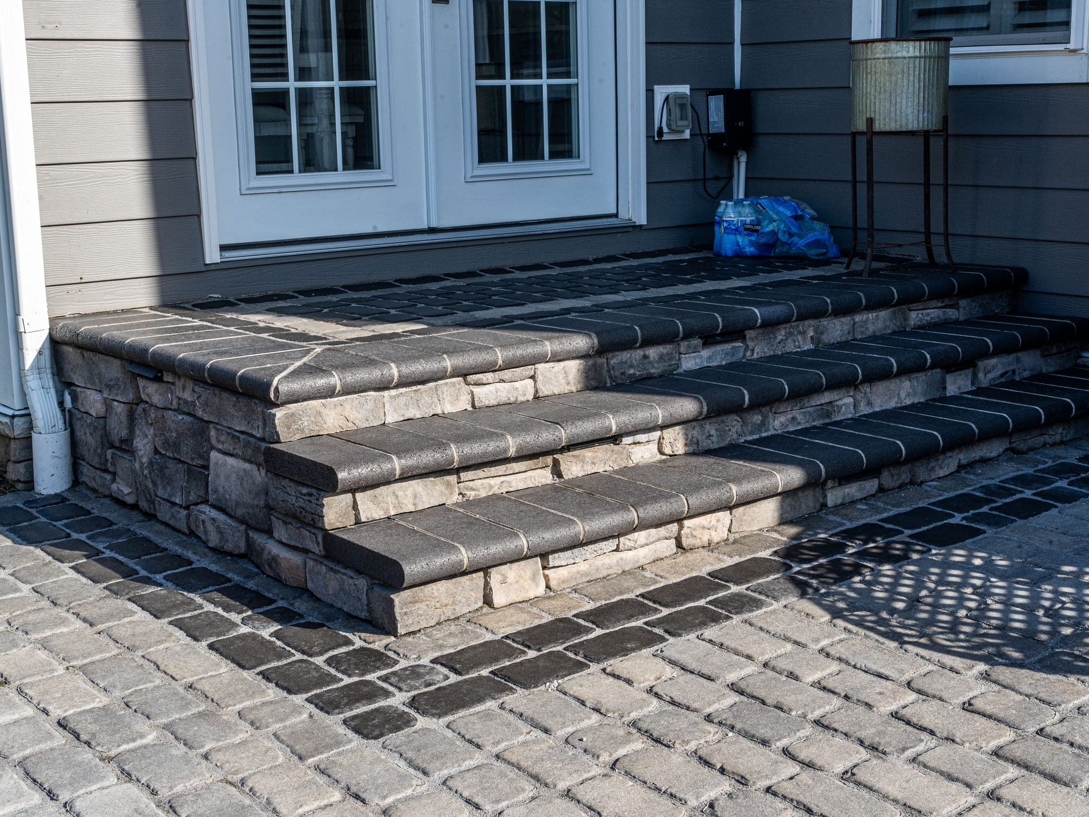 Stone entry steps leading onto a cobble paver patio