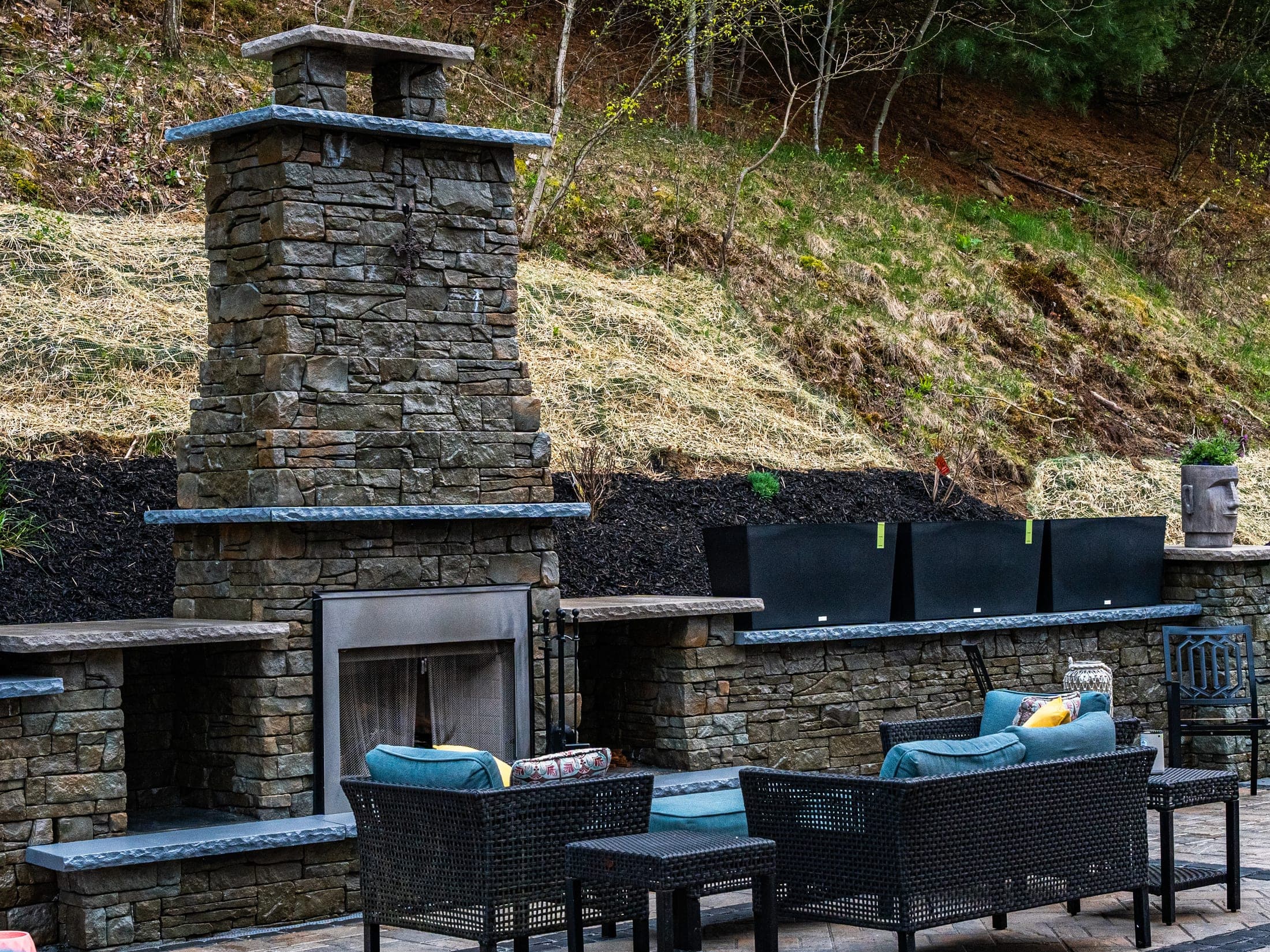 Stone fireplace next to an outdoor kitchen