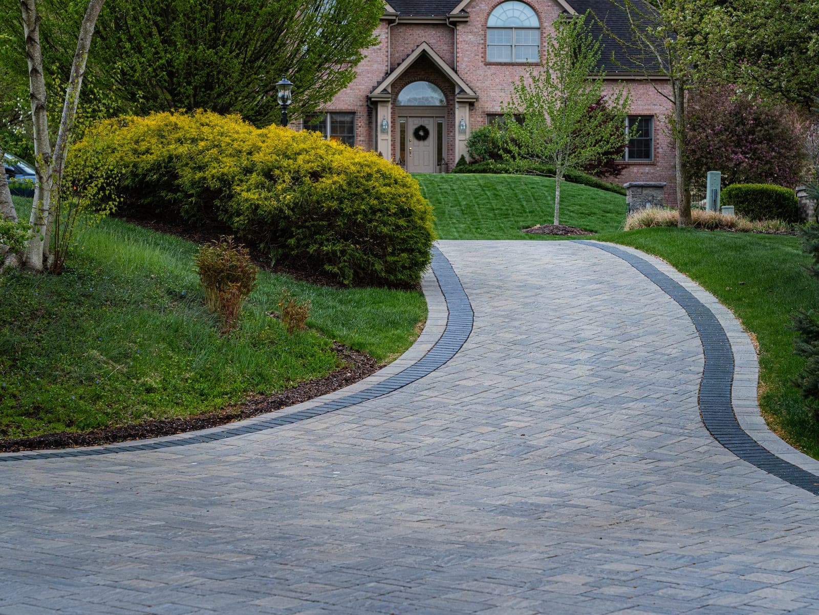 Curved paver driveway at dusk