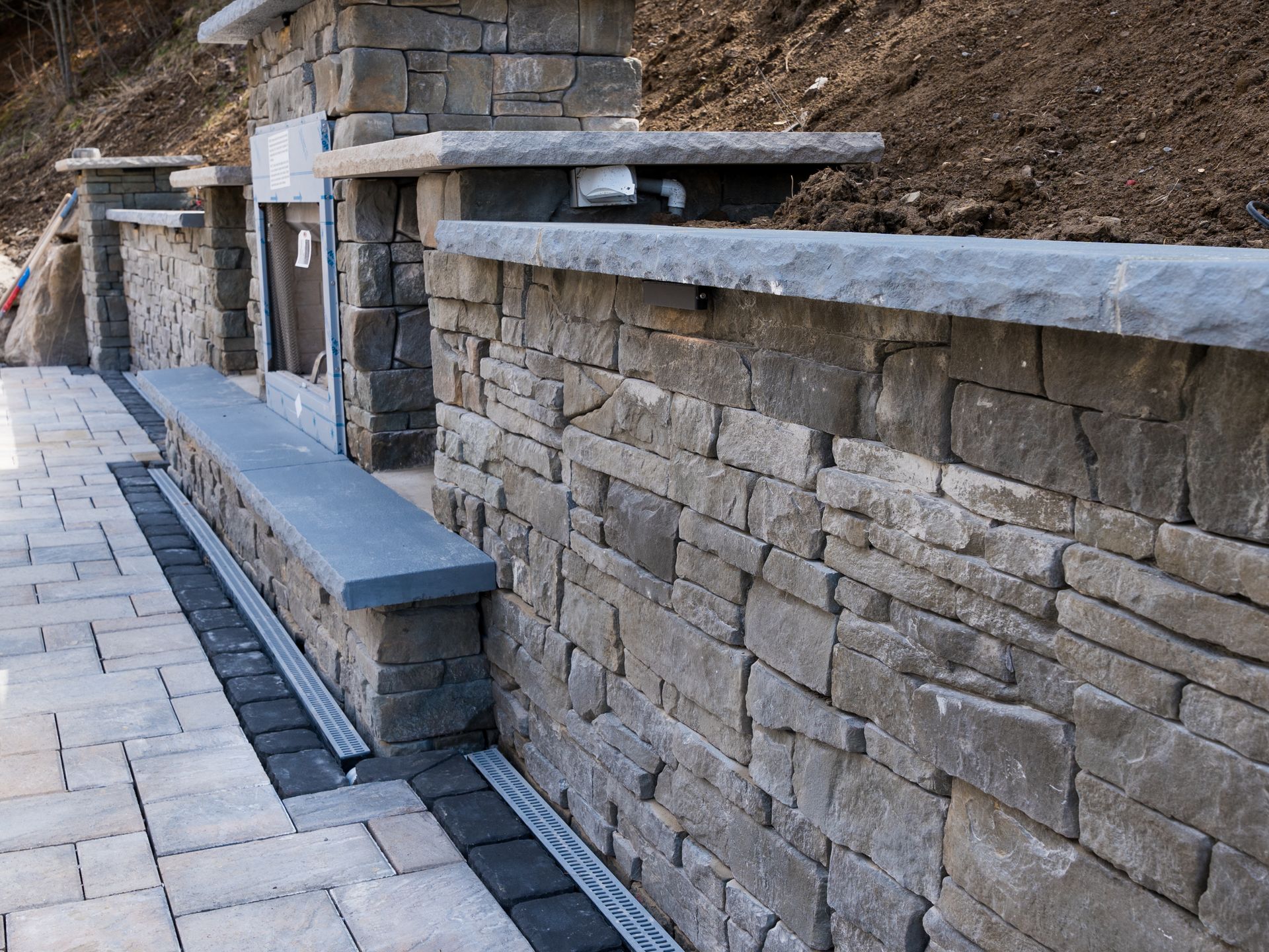 Outdoor fireplace with stone seating wall