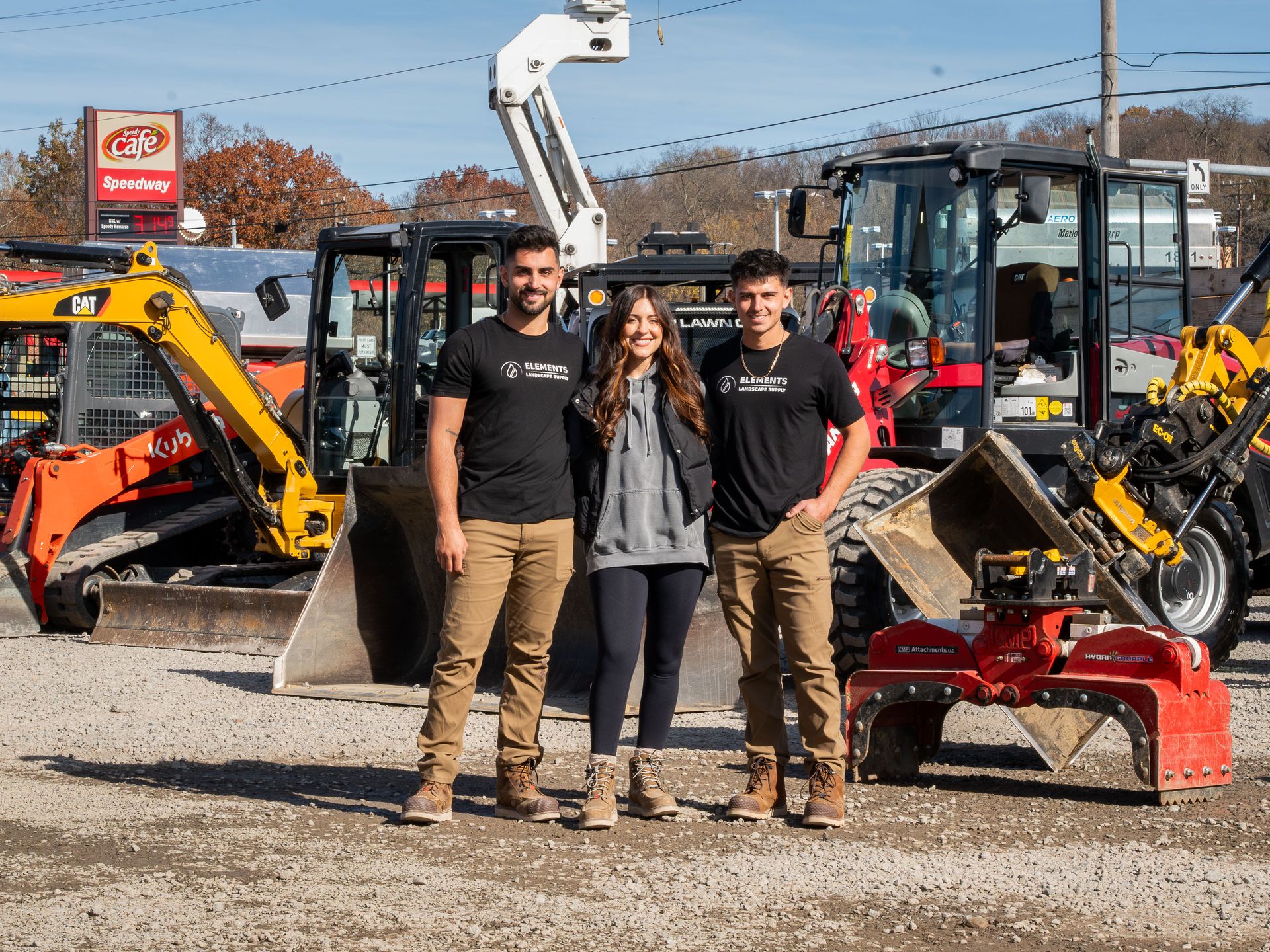 Elements Landscape Management team members standing in front of heavy equipment